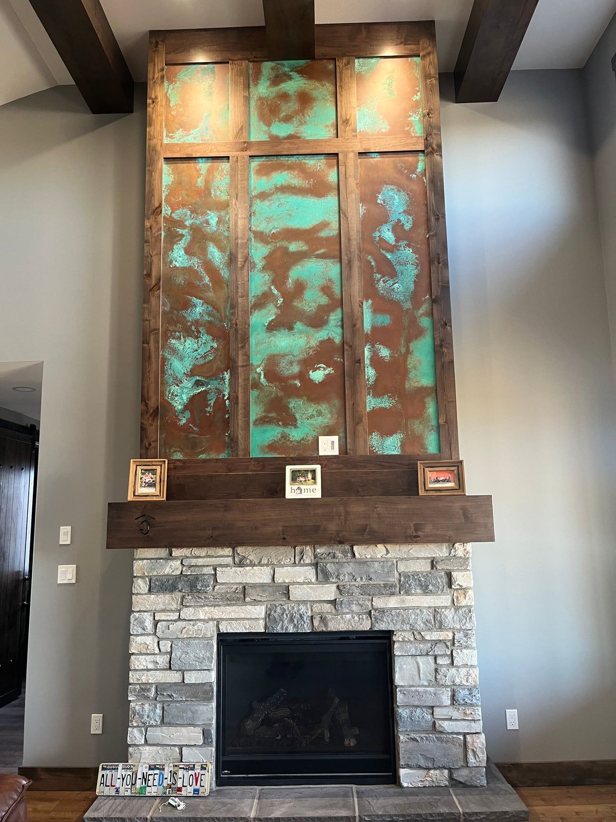 Stone fireplace with Tiffany Green Swirl heavy gauge patina copper panels framed in wood