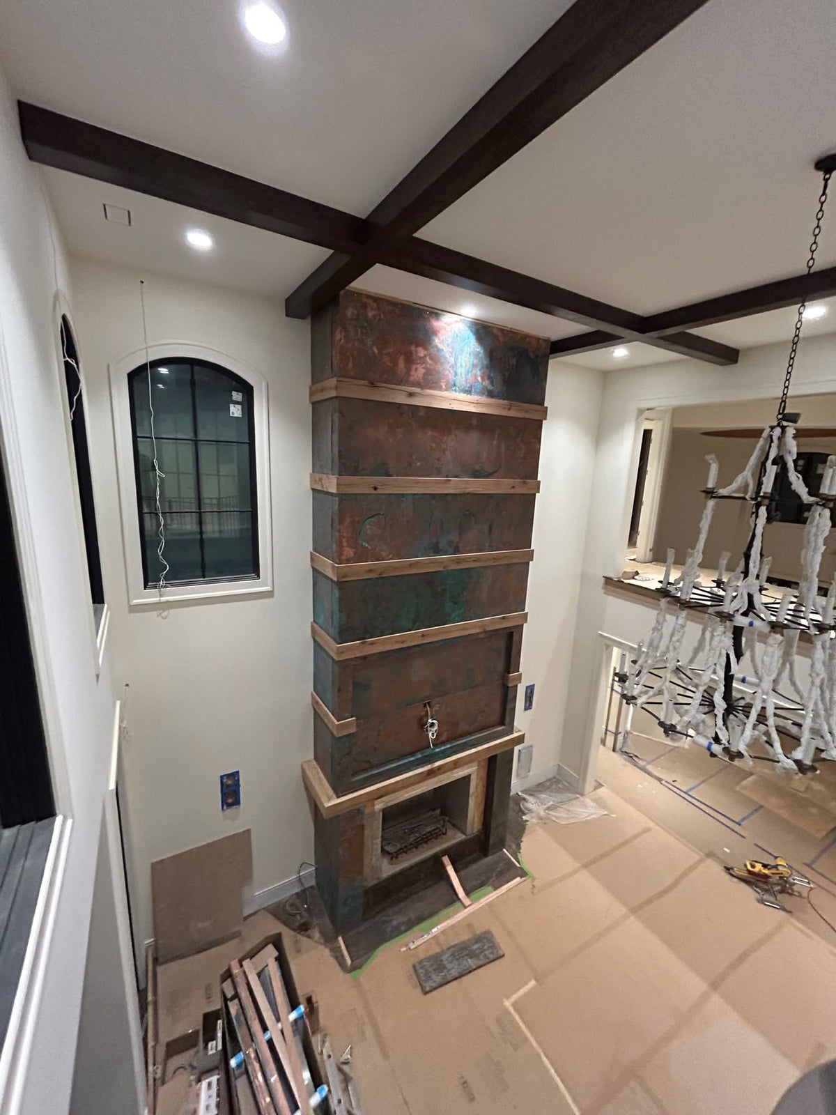 Floor-to-ceiling fireplace surround covered in Tiffany Green Swirl heavy gauge patina copper