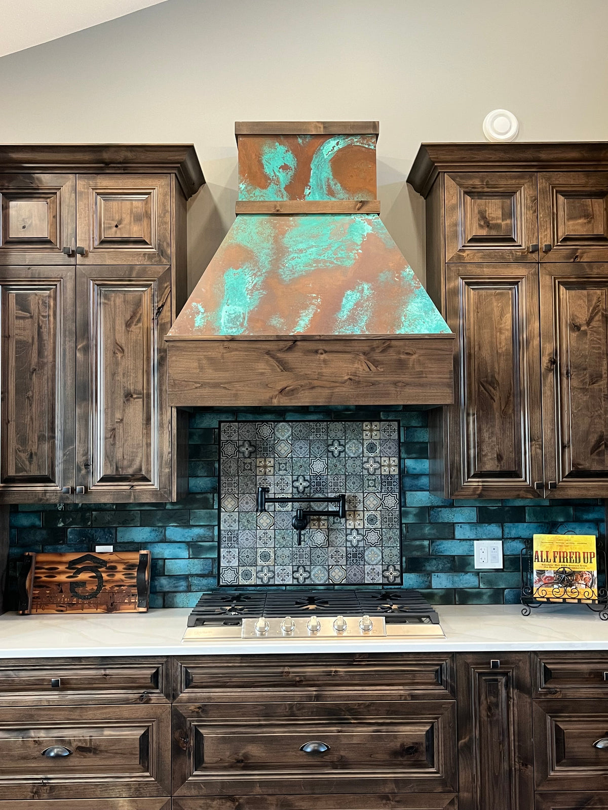 Range hood covered in Tiffany Green Swirl heavy gauge patina copper