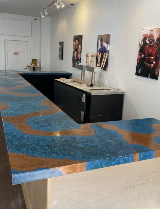 A bar with a blue countertop and pictures on it.